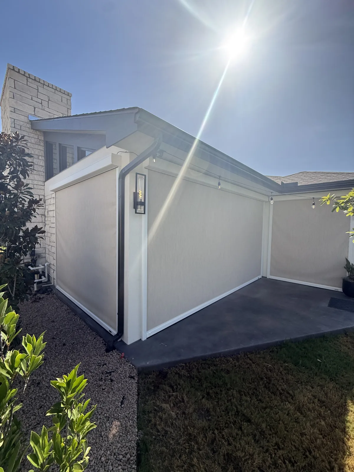 Finished patio exterior with a MagnaTrack motorized screen and housing integrated into the structure