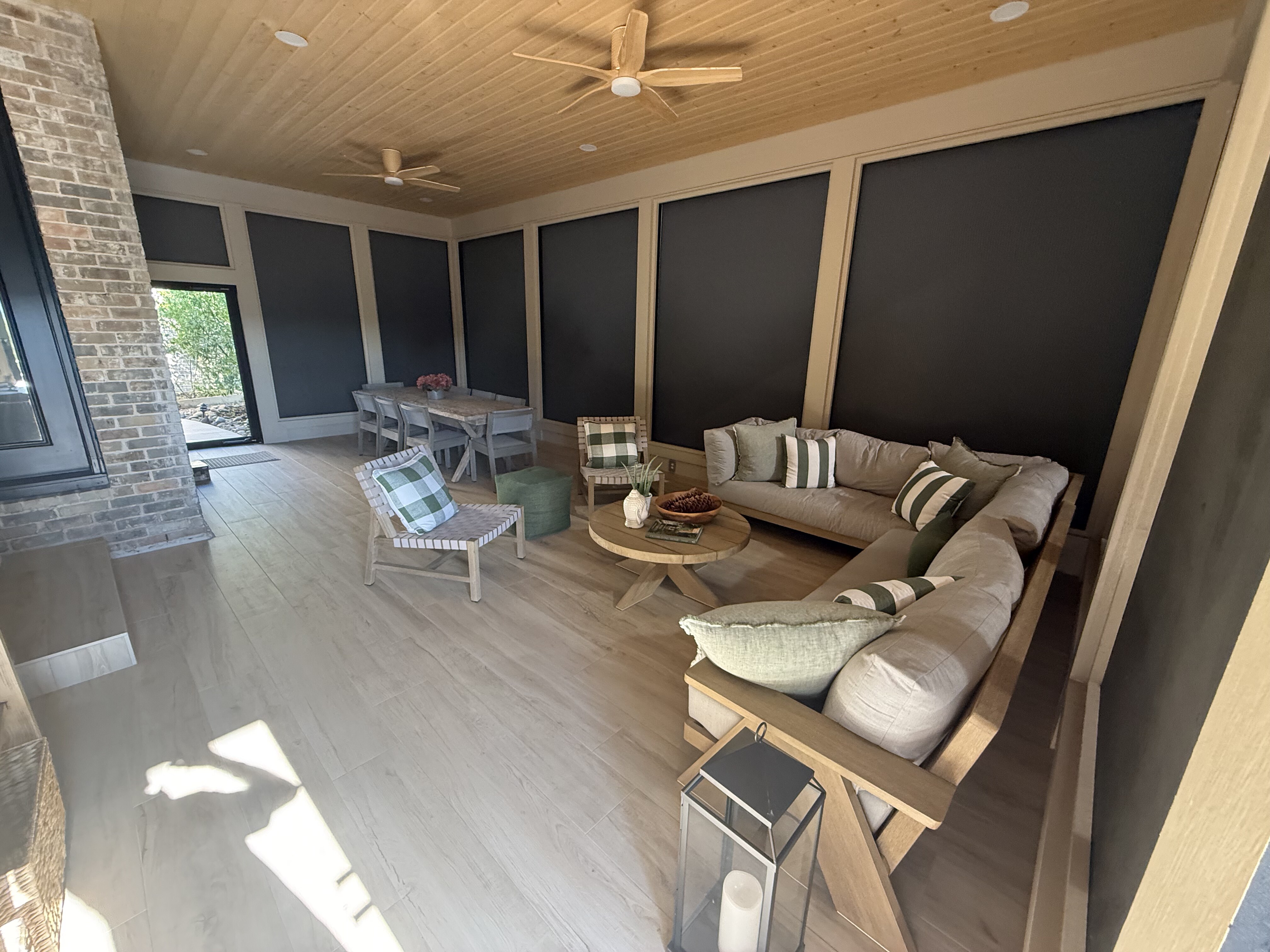 Covered patio with MagnaTrack retractable screens, ceiling fan and outdoor dining furniture overlooking a landscaped yard