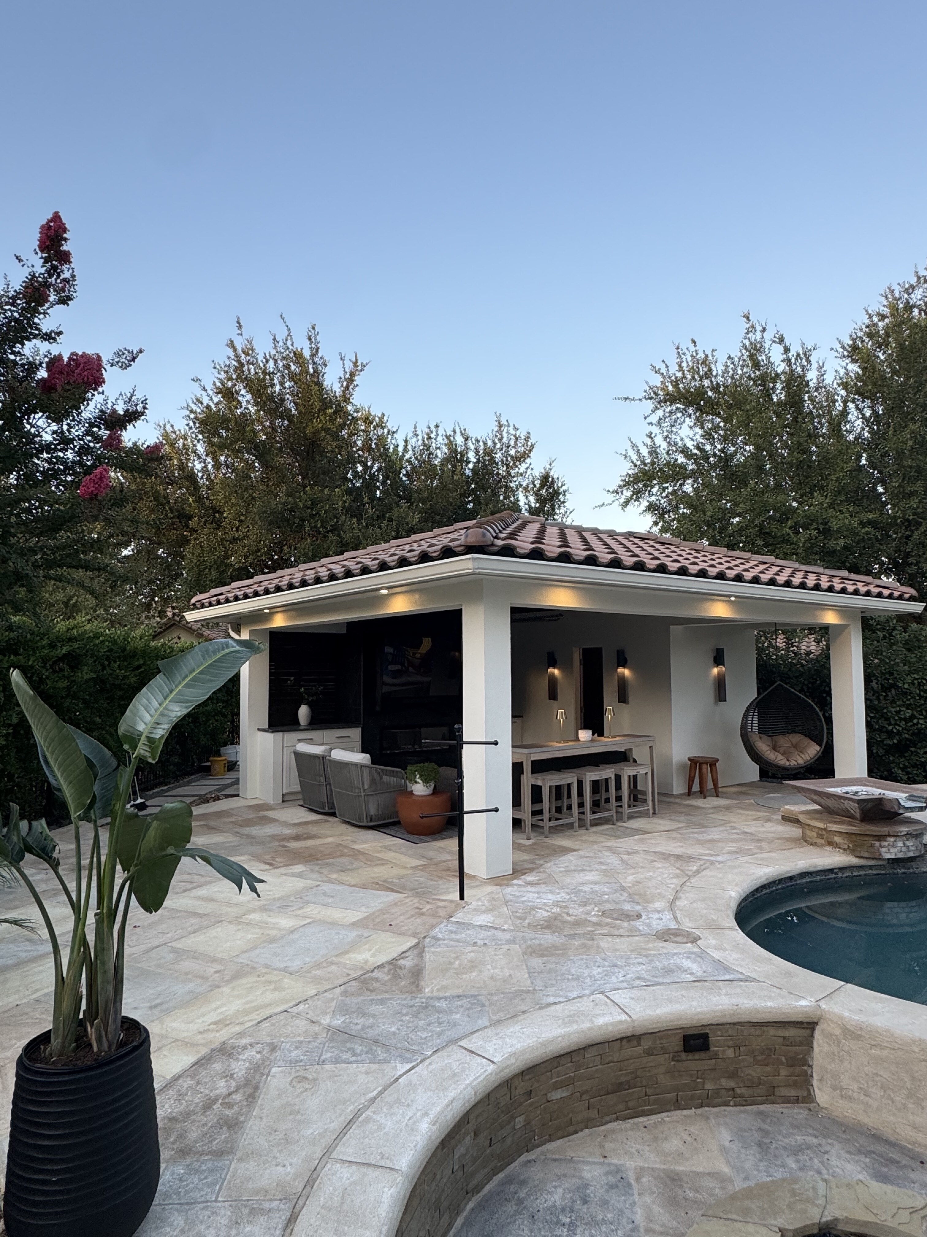 Open-air pool cabana with a tiled roof, bar seating and lounge space