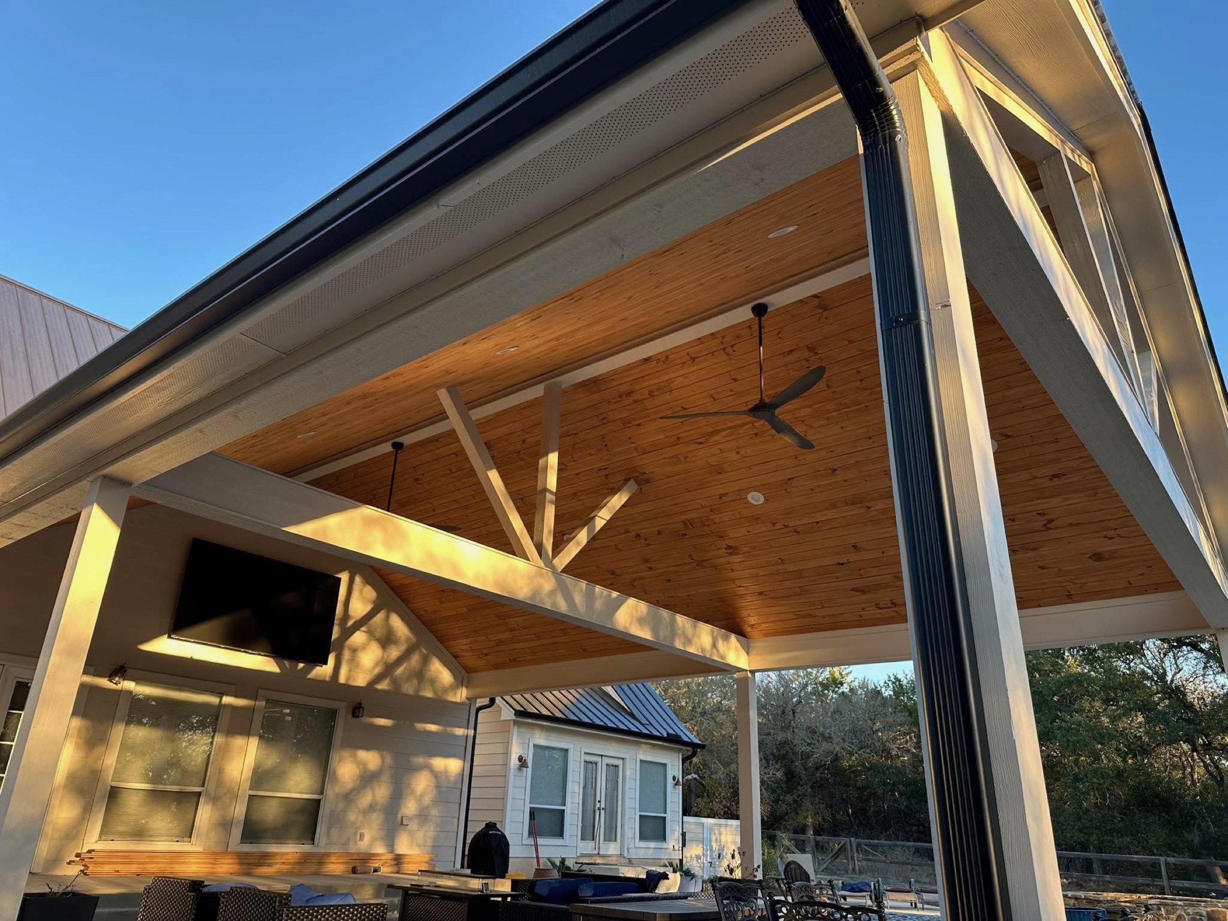 Gabled patio cover with a cedar ceiling, exposed truss and ceiling fans