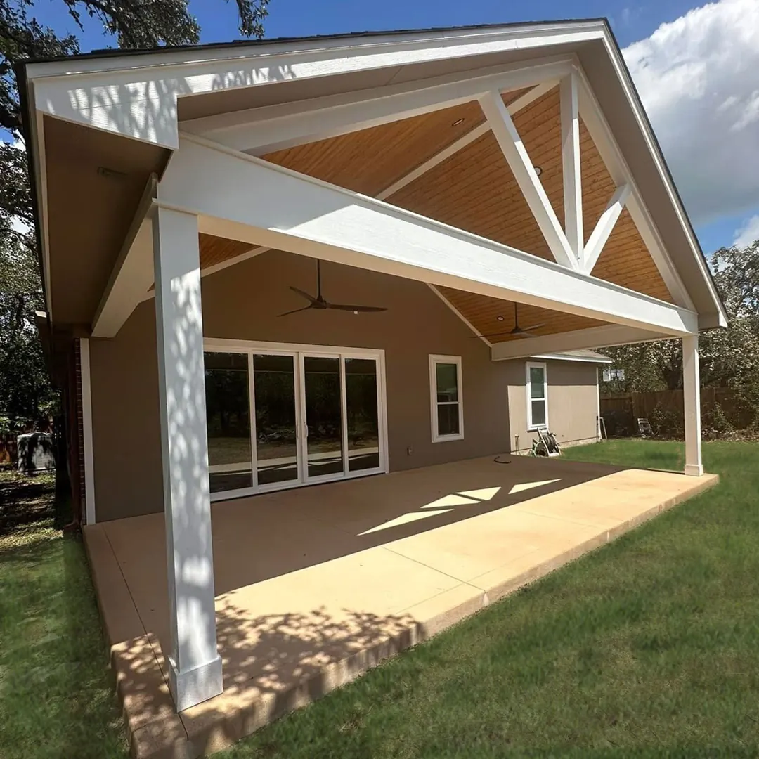 Gabled patio cover with a stained wood ceiling attached to the rear of a home