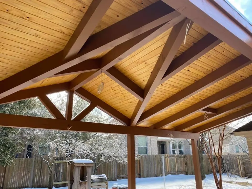 Freestanding timber truss pavilion with a stained wood ceiling and ceiling fan