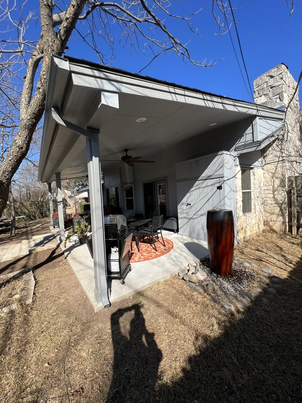 Long attached patio cover running along the rear elevation of a hillside home