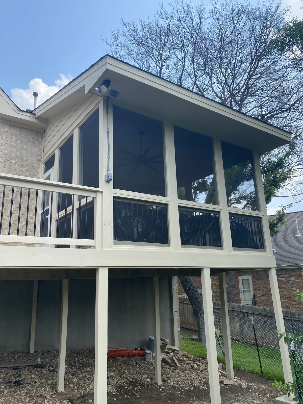 Elevated screened porch built over a support structure at the rear of a home