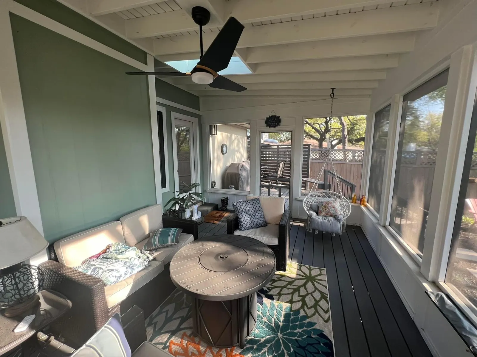 Furnished screened porch with lounge seating, a ceiling fan and painted walls