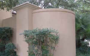 Rounded exterior stucco wall with plants
