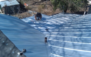 TWT worker installing metal roofing sheets