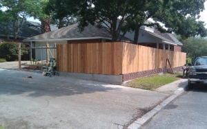 Wooden fence being constructed along the side of a house