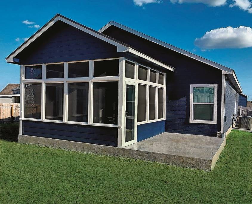 Blue house with a screen room installed in the porch area, and a large yard in Austin, TX