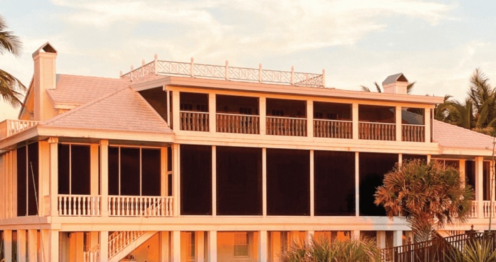 Grand white house with a balcony covered with a black residential Magna track screen in Austin, TX