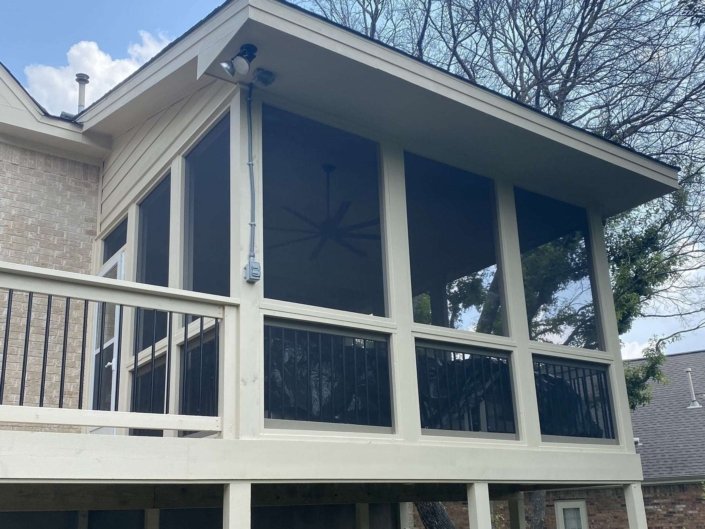 Outdoor patio area with screen enclosure of an elegant white coloured home in Austin, TX