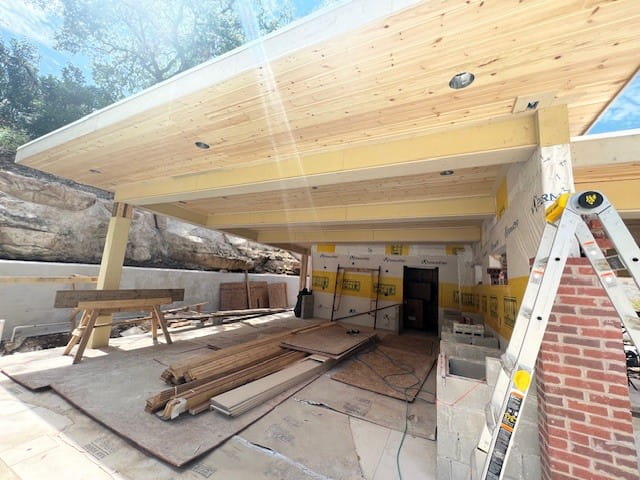 Modern Austin home construction with wood ceiling, ladder, and materials in garage area