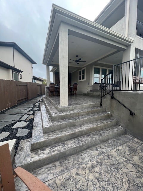 Exterior case study featuring covered patio, concrete steps, and modern home design in Austin, TX